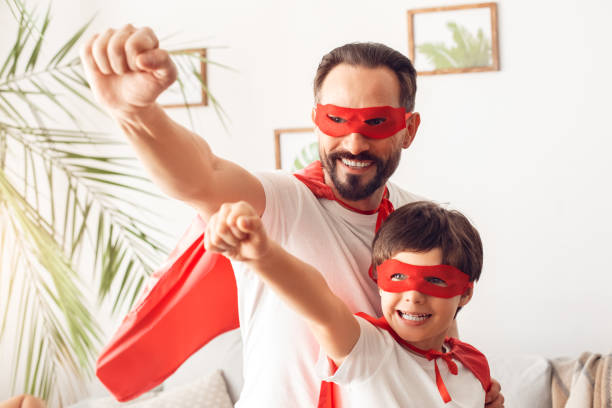 istock Father and son in superheroe costumes at home standing hands forward confident superpowers 1278330266