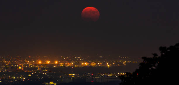 istock A dark red harvest moon rise over a city 1278330526