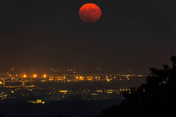istock A dark red harvest moon rise over a city 1278330527