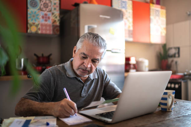 istock Senior man using laptop at home 1278336166