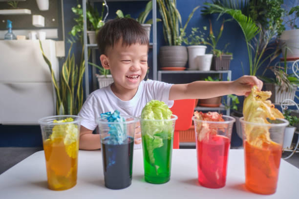 istock Asian kindergarten boy having fun making Rainbow Cabbage Experiment, Kid learn about how plants thrive by pulling water through its vein system 1278338610