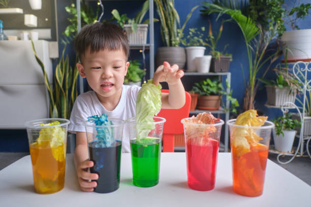 istock Asian kindergarten boy having fun making Rainbow Cabbage Experiment, Kid learn about how plants thrive by pulling water through its vein system 1278338620