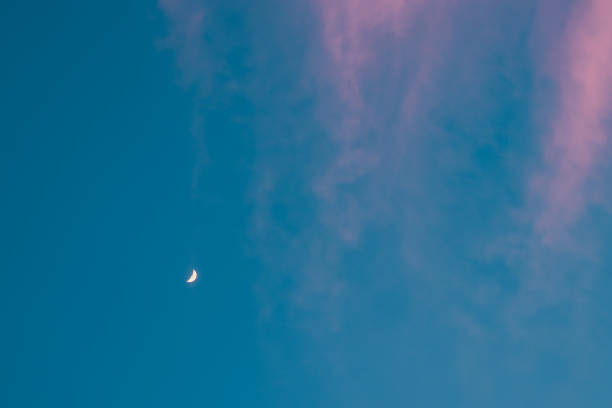 istock Half moon. Growing crescent at turquoise sky with pink long clouds. Copyspace 1278342367