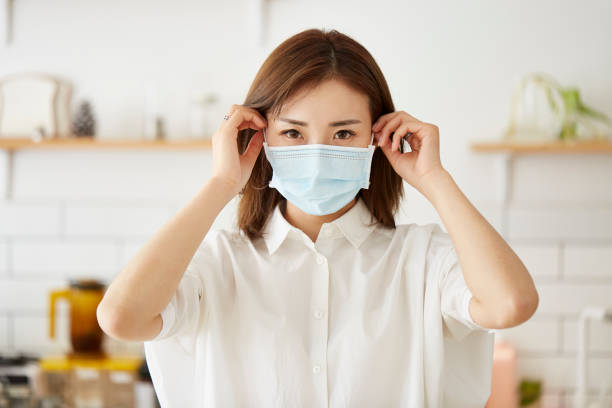 istock young asian woman putting on a face mask 1278352119