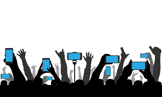 Hands holding phones, smartphones on background of raised human hands. Silhouette of cheerful crowd of people at concert or sport event and etc. Vector illustration