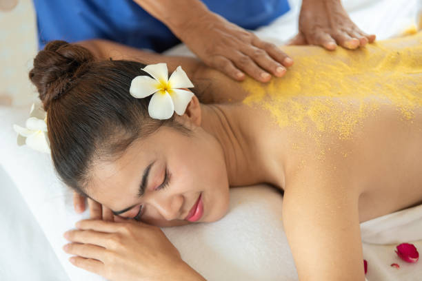 beautiful asian woman having exfoliation treatment with body scrub in spa salon, scrubbing and skin care concept, enjoying and relaxing time - exfoliating scrub imagens e fotografias de stock