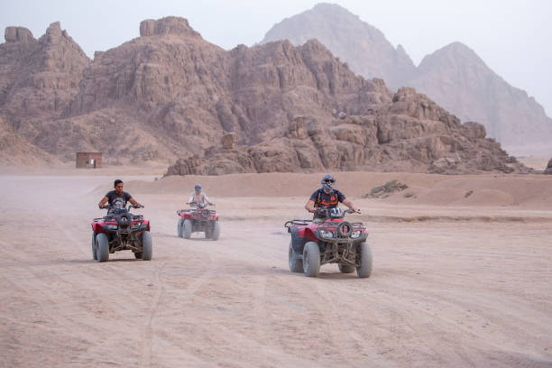 quady safari na pustyni w pobliżu szarm el-szejk, egipt. potężne szybkie off-road napęd na cztery koła atv, motocykle na piaszczystej pustyni, rajd przed wysokimi górami - off road vehicle quadbike quad racing motocross zdjęcia i obrazy z banku zdjęć