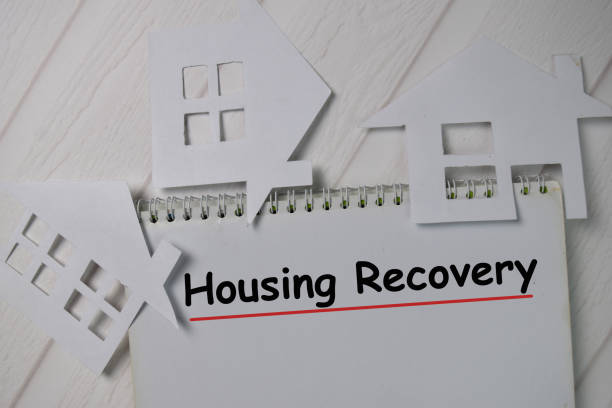 istock Housing Recovery text write on a book isolated wooden table. 1278365429