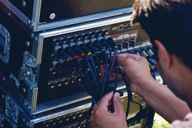 Sound engineer plugging audio cable on studio system boxes. Cable, Engineer, Equipment, Power Supply, Steel sound technician stock pictures, royalty-free photos & images