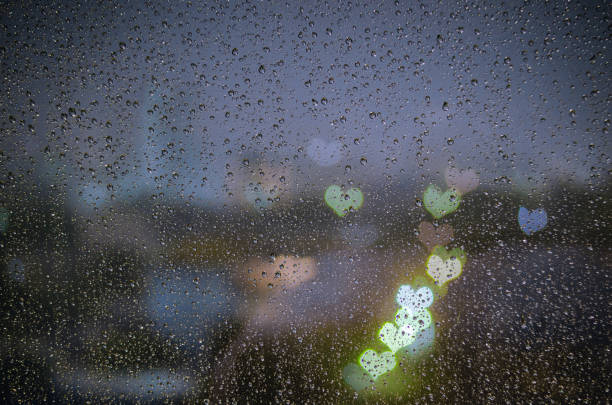 istock Rain drop on window with colorful bokeh love shape lights. 1278369303