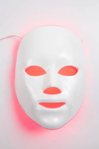 Photo of Color therapy mask glowing on the white background.