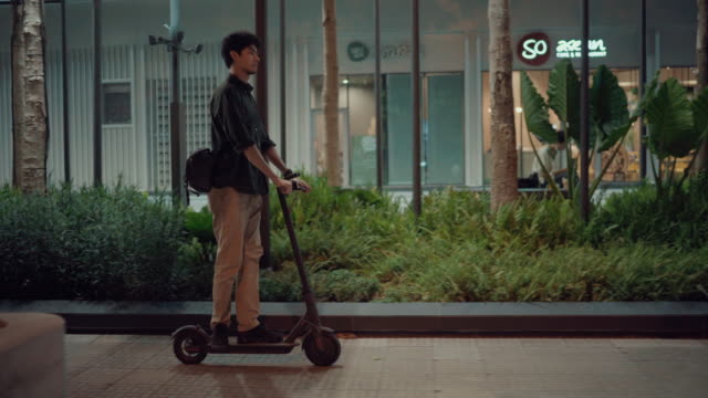 Businessman commuting on electric scooter after work