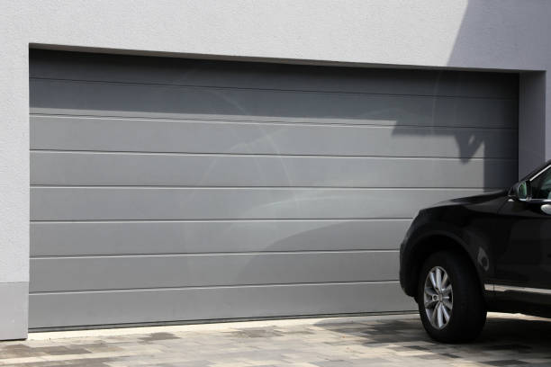 istock Modern garage door with black car parked in front 1278372702