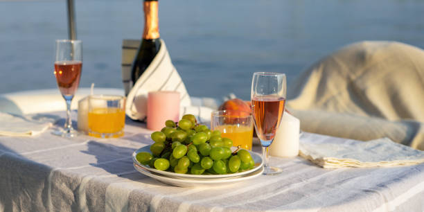 petit déjeuner romantique ou dîner sur un yacht à moteur. la lumière du soleil dure. - beach table peach fruit photos et images de collection
