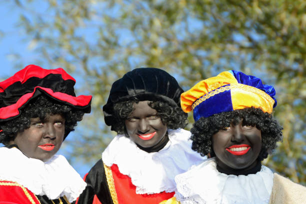Black Pete. Nuenen -Netherlands 24 Novmber 2019 Sinterklaas feast. Group of black make-up assistants of Sinterklaas. Inhabitants of Nuenen disguise as a black Pete. to entertain children during the entry Feast.  Local residents in a temporary role position. zwarte piet stock pictures, royalty-free photos & images