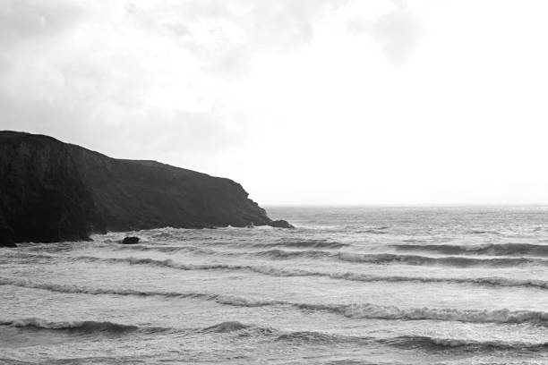 istock Big waves crash in the bay with rugged cliff face 1278374057