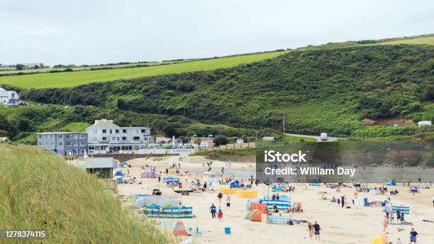 Classic Cornish Beach Scene In The Summer Lots Of Windbreaks And Parasoles Set Up Along The Shore Stock Photo - Download Image Now