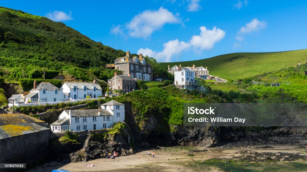 Houses line the harbour edge at Port Isacc on a sunny summers day A beautiful summers day in the coastal fishing village of Port Issac on the north coast of Cornwall. A popular tourist spot after the filming of the hit TV show Doc Martin Cornwall - England Stock Photo