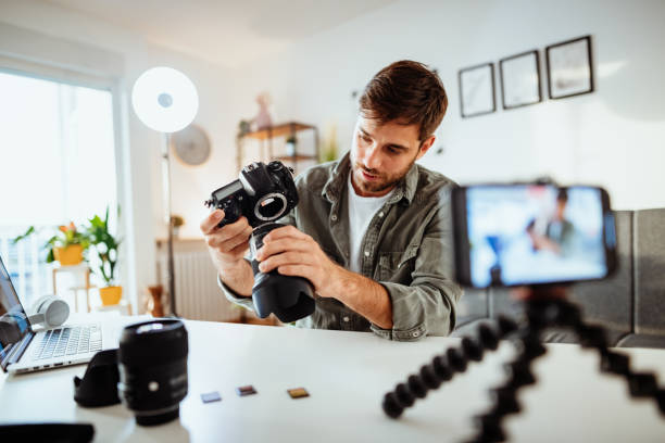 influencer testet objektiv auf kamera für seinen videoblog - bildungskurs online - camera lens home video camera broadcasting stock-fotos und bilder
