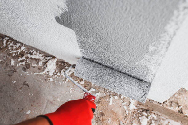 istock Painting the wall with a roller white paint - facade finishing 1278385061