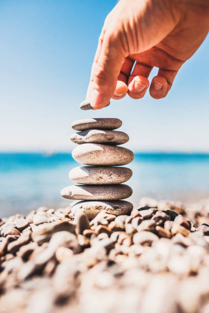 istock A man hand adds stone to the tower 1278386189