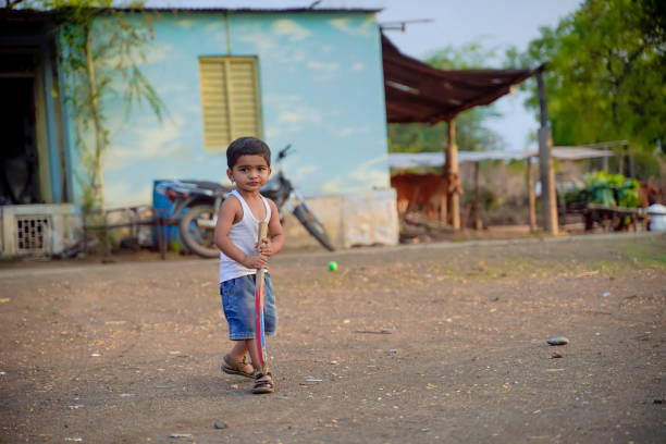 istock Cute indian little child playing cricket at home 1278389930