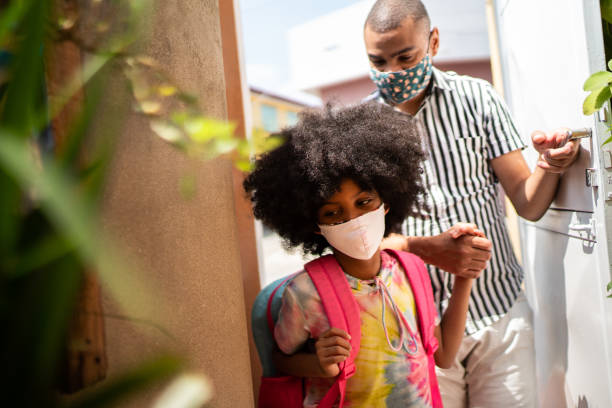 istock Girl arriving from school with her father using face mask 1278390633