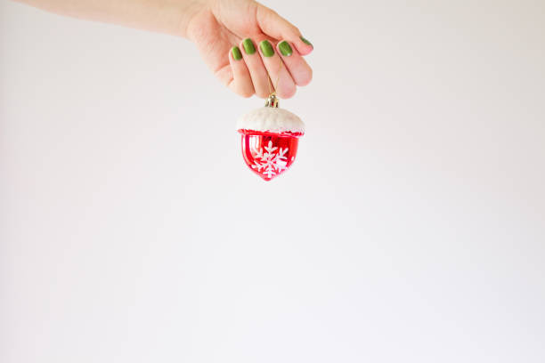 istock Red Christmas ball on a white background in a female hand mock up with copy space. Creative template with a bright Christmas tree toy in the snow, with snowflakes. Christmas decoration concept 1278390645