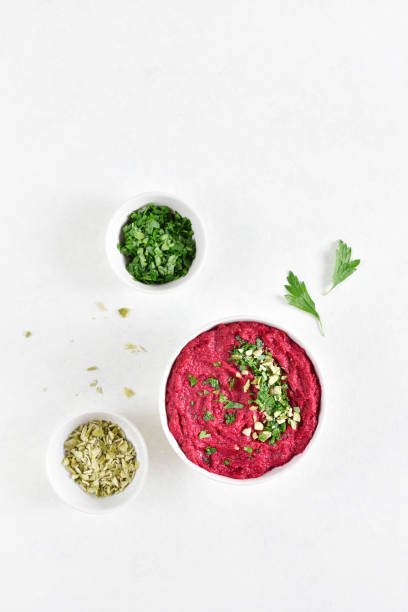 Homemade beet hummus in bowl over white stone background with free text space. Top view, flat lay