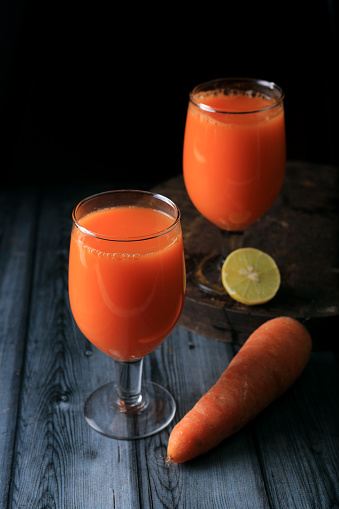 Carrot and glass of fresh juice on Dark background,selective focus