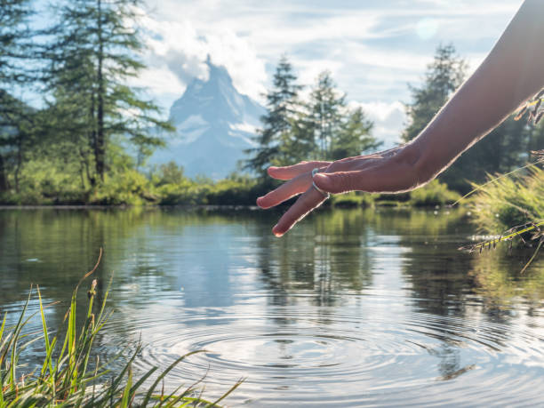 istock Female's finger touching water surface from alpine lake 1278393269