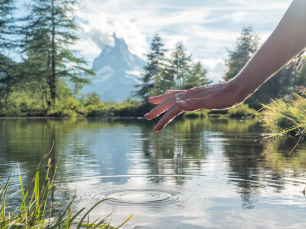 istock Female's finger touching water surface from alpine lake 1278393447