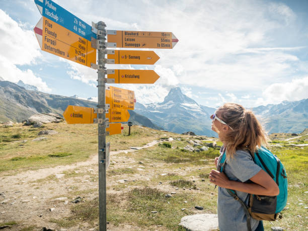 istock Woman hiker looks at directional signs 1278393531