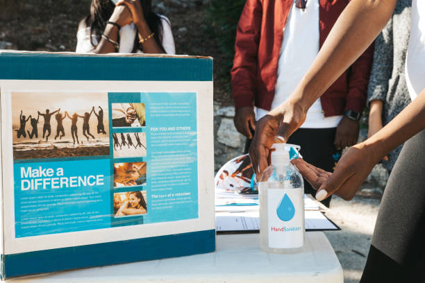 istock Volunteer sanitizing her hands during a charity organization event 1278394222