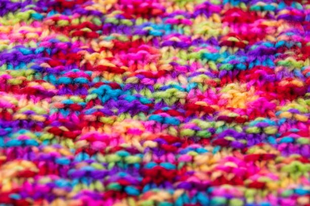 Knitted blue orange and beige background. Large knitted fabric with a pattern. Close-up of a knitted blanket. Banner