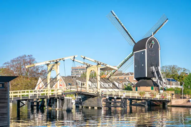 Windmill "De Put" and drawbridge "Rembrandtbrug" in the historic city of Leiden, Holland. In this neighbourhood the famous dutch painter Rembrandt was born.