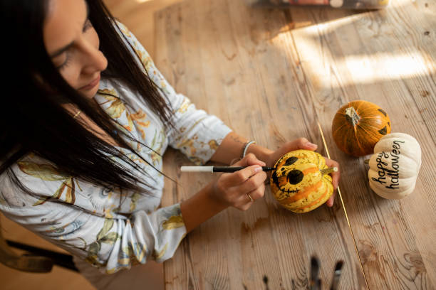 istock Woman making pumpkin Jack O’ Lantern for Halloween 1278398865