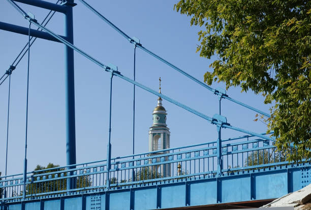 Pedestrian bridge over the Tsna river in Tambov Pedestrian bridge across the Tsna river in Tambov, through which the bell tower of the Transfiguration Cathedral is visible tambov russia stock pictures, royalty-free photos & images