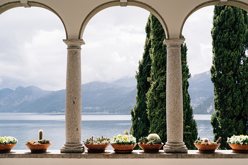 Flower pots with succulents in arches with columns overlooking Lake Como in Italy. High quality photo