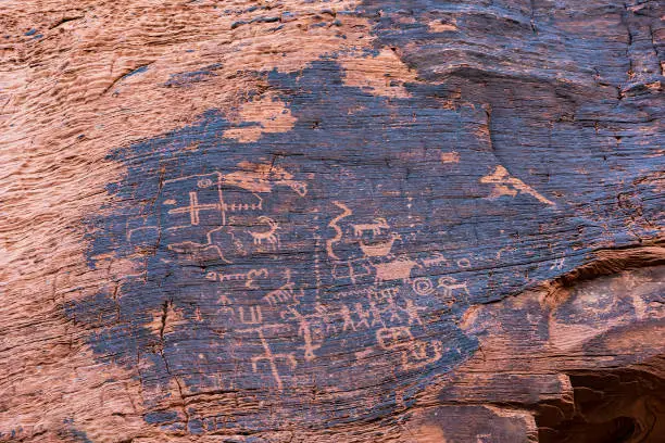 Ancient rock art (petroglyphs) by  Ancestral Puebloans - native Americans - seen during hiking at Mouse's Tank hiking trail in Valley of Fire State Park. Nevada in USA