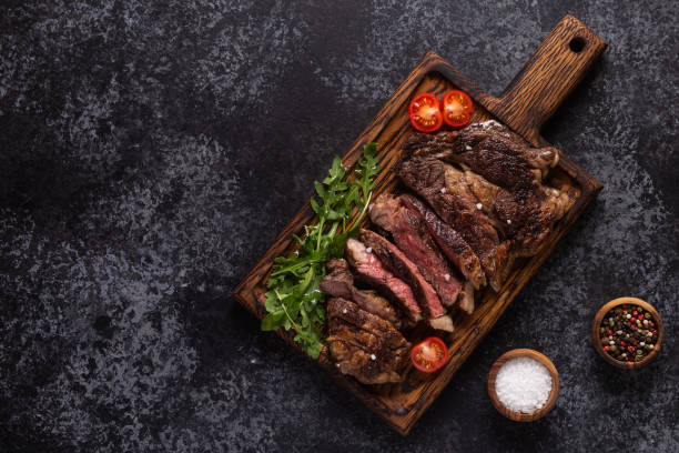 istock Grilled beef steak with spices on a wooden board 1278417343