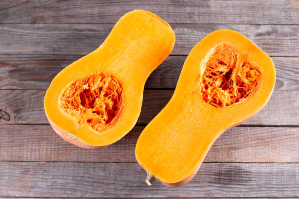 istock Butternut squash sliced in half. Sliced butternut squash over old wood background. 1278419406