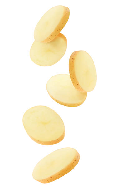 Falling peeled slices of raw washed potato isolated on white