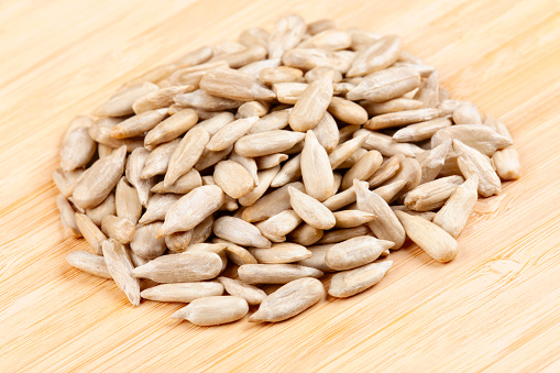 A close up  of sunflower kernels, a healthy and tasty snack isolated on a wooden background