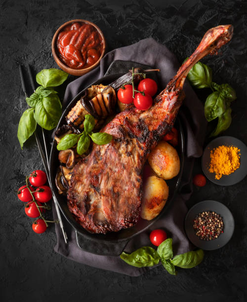 Baked lamb leg with vegetables and sauce. Roasted meat. The view from the top Baked lamb leg with vegetables and sauce. Roasted meat. The view from the top lamb meat photos stock pictures, royalty-free photos & images