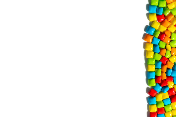 istock Candies. Multicolored candies on the right on a white isolated background top view frame copy space. Chewing gum, and dragees are scattered. Space for text. 1278424108