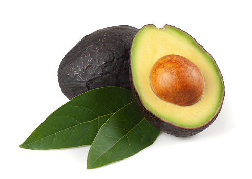 Avocado cut in half, with leaves, on white background