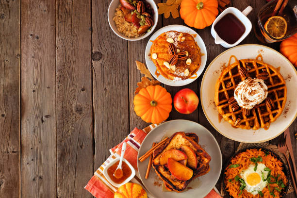 Assorted autumn breakfast or brunch items. Side border against a dark wood background with copy space.