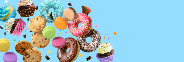 과자와 과자 콜라주. 도넛, 컵케이크, 쿠키, 마카롱이 푸른 배경을 타고 날아다간다. - candy 뉴스 사진 이미지