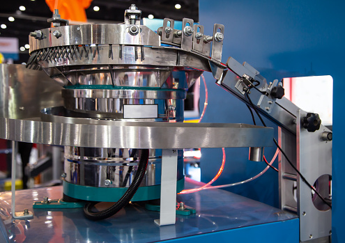 Bowl screw feeder to optical screw sorting machine. Industrial manufacturing machinery